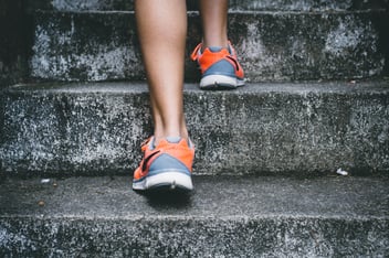 Woman walking up steps. Photo by Bruno Nascimento. Courtesy of Unsplash