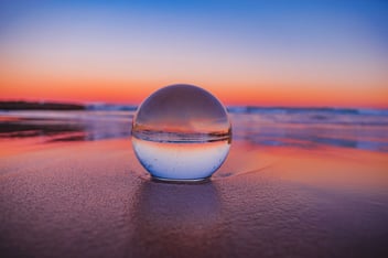 Crystal ball on a beach with a sunset 