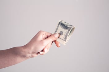 Person holding folded $100 bills